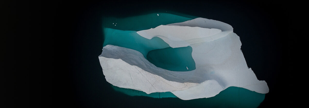 Eisberg, wo man noch etwas von der Eisschicht unter der Wasseroberfläche sieht